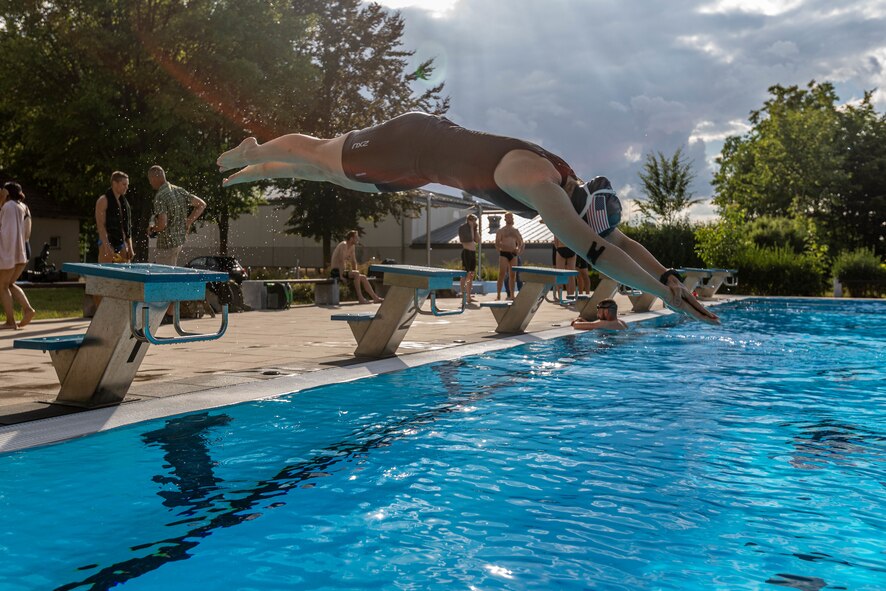A woman dives into a pool.