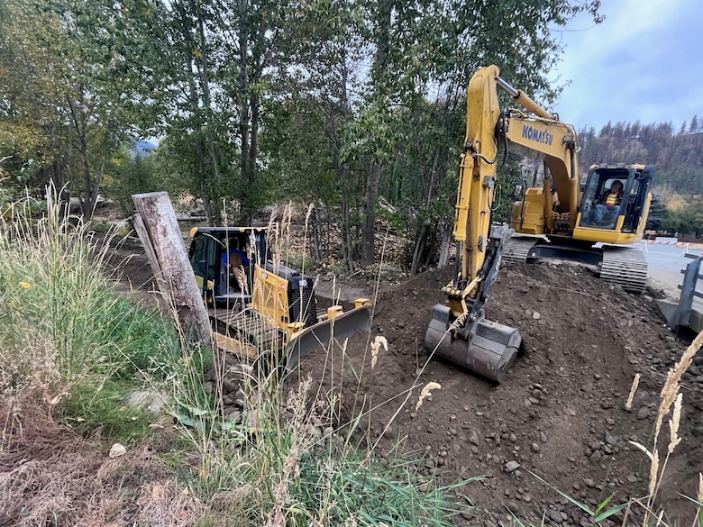 Photo of a man operating a bulldozer extracting dirt from Salmon Creek, a creek in the town of Conconully, in Okanogan County, in Washington State.