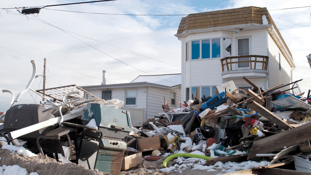 Debris fills the area in front of a house.