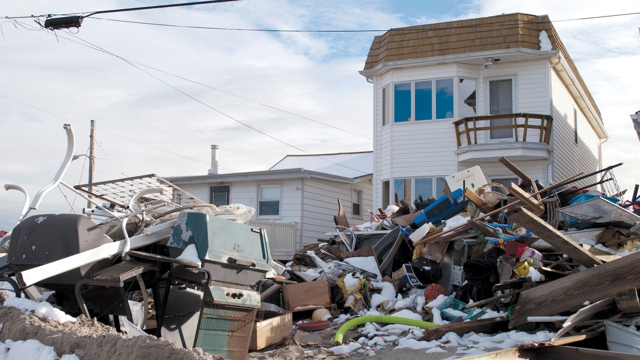 Debris fills the area in front of a house.