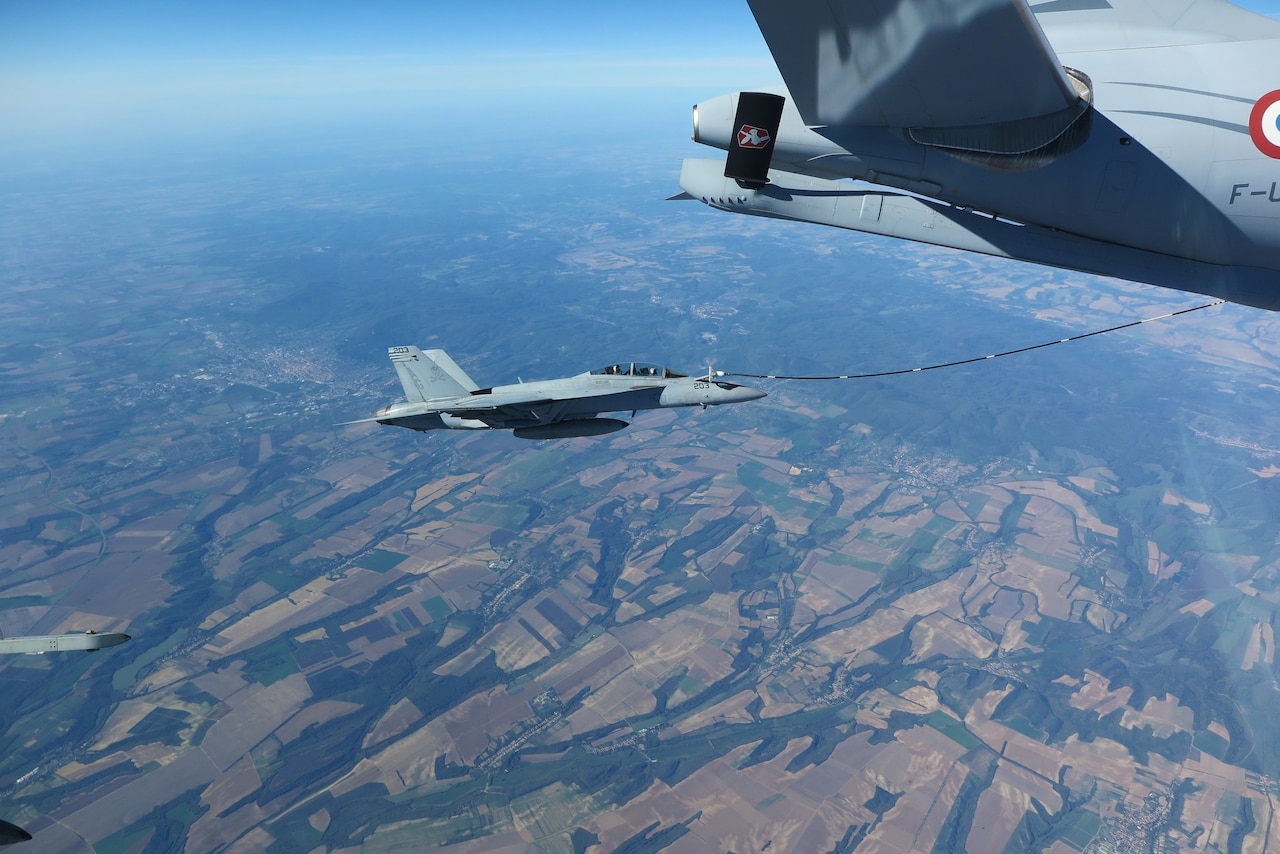 A jet is refueled in midair.