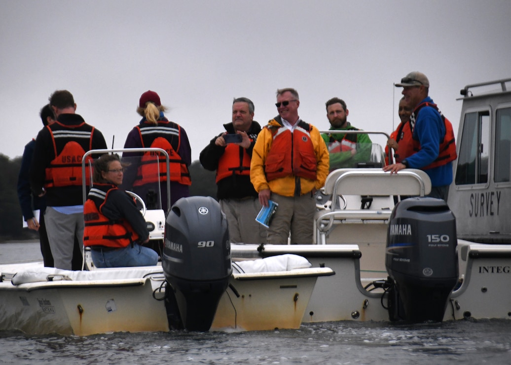 People in life vests are in a boat and talking