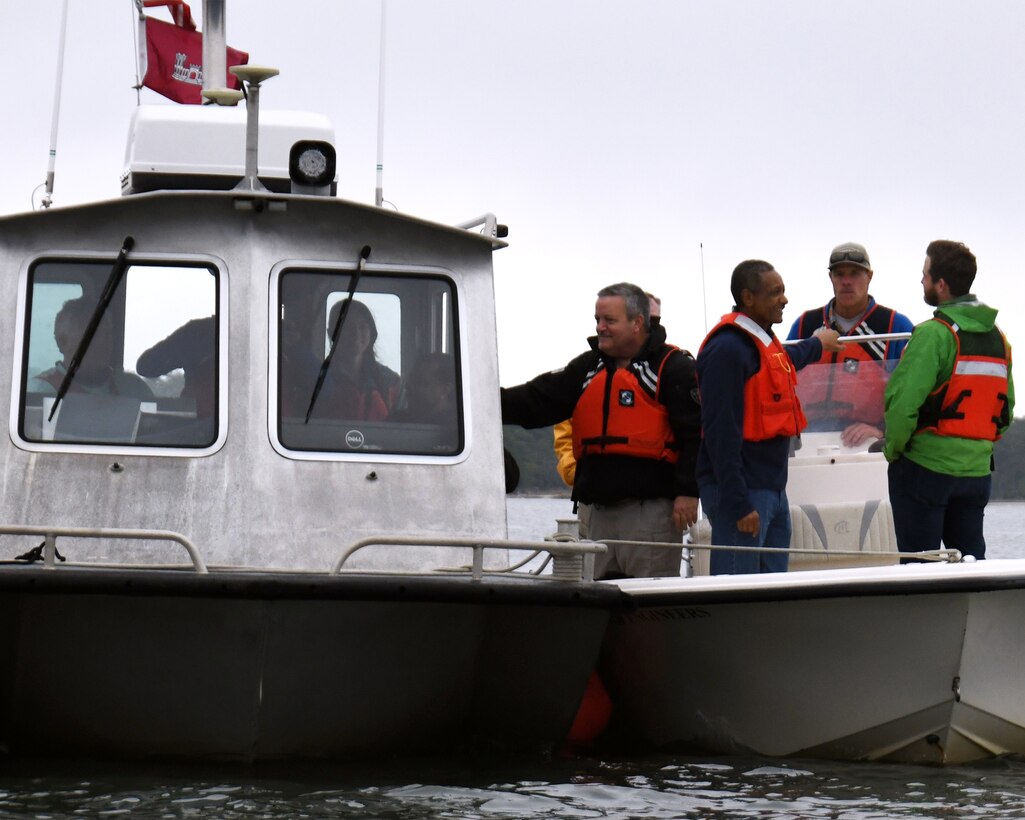 People in life vests are in a boat and talking