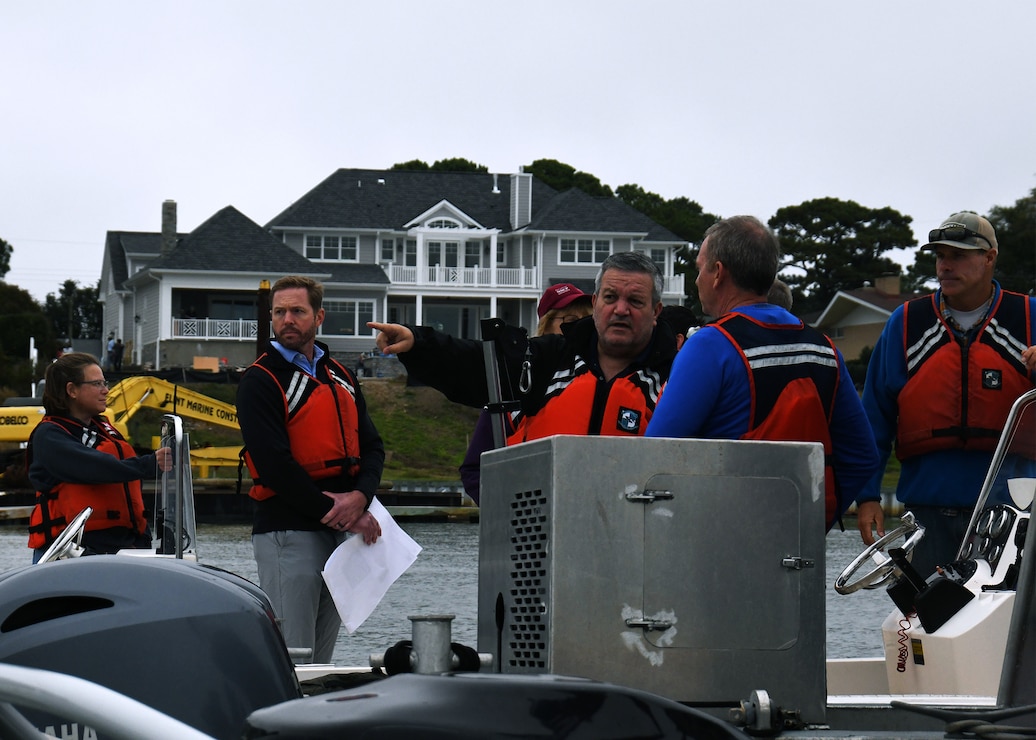 People in life vests are in a boat and talking