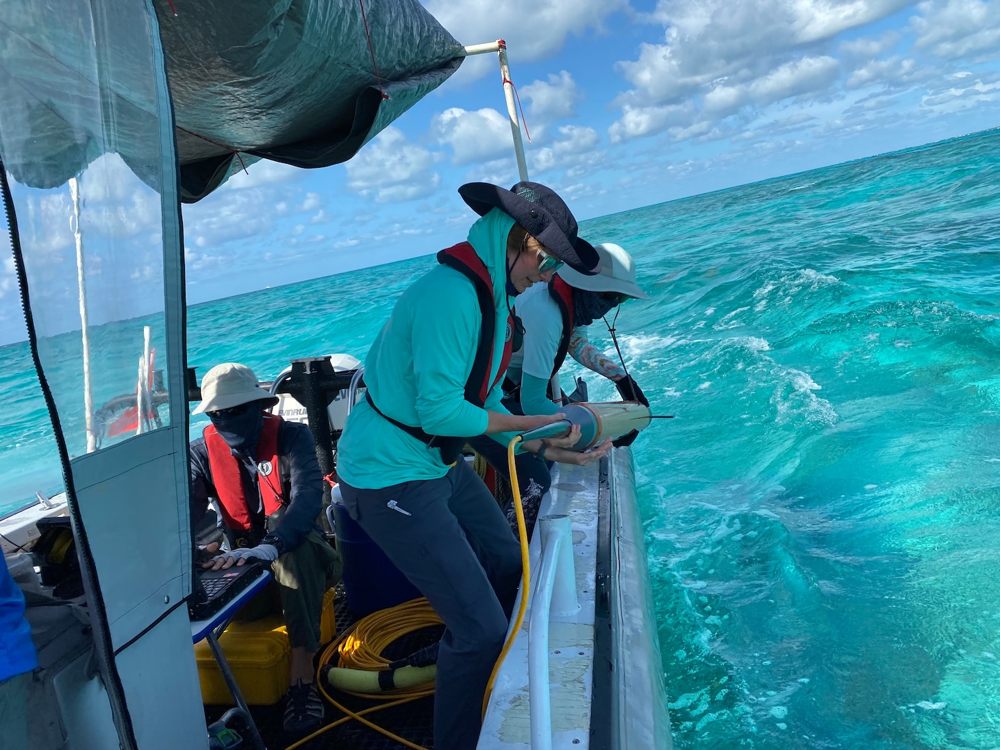 Blair Atcheson (NHHC) and Madeline Roth (NOAA) launch the marine magnetometer. This instrument is deployed in water and towed behind the survey boat to record magnetic anomalies on the seabed. Shipwrecks like Alligator record as large magnetic anomalies due to the large amount of iron ballast on board.