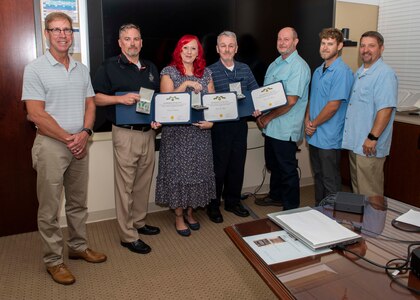 (left) Naval Surface Warfare Center Panama City Division (NSWC PCD) Technical Director Dr. Peter Adair stands with the NSWC PCD General Equipment (GE) Branch team after presenting three U.S. Navy Civilian Service Medals at Naval Support Activity Panama City, Fla., Oct. 14. The team features three government employees and three contractors who provide the workforce with the tools necessary to create and enhance products for the warfighter. (U.S. Navy photo by Eddie Green)