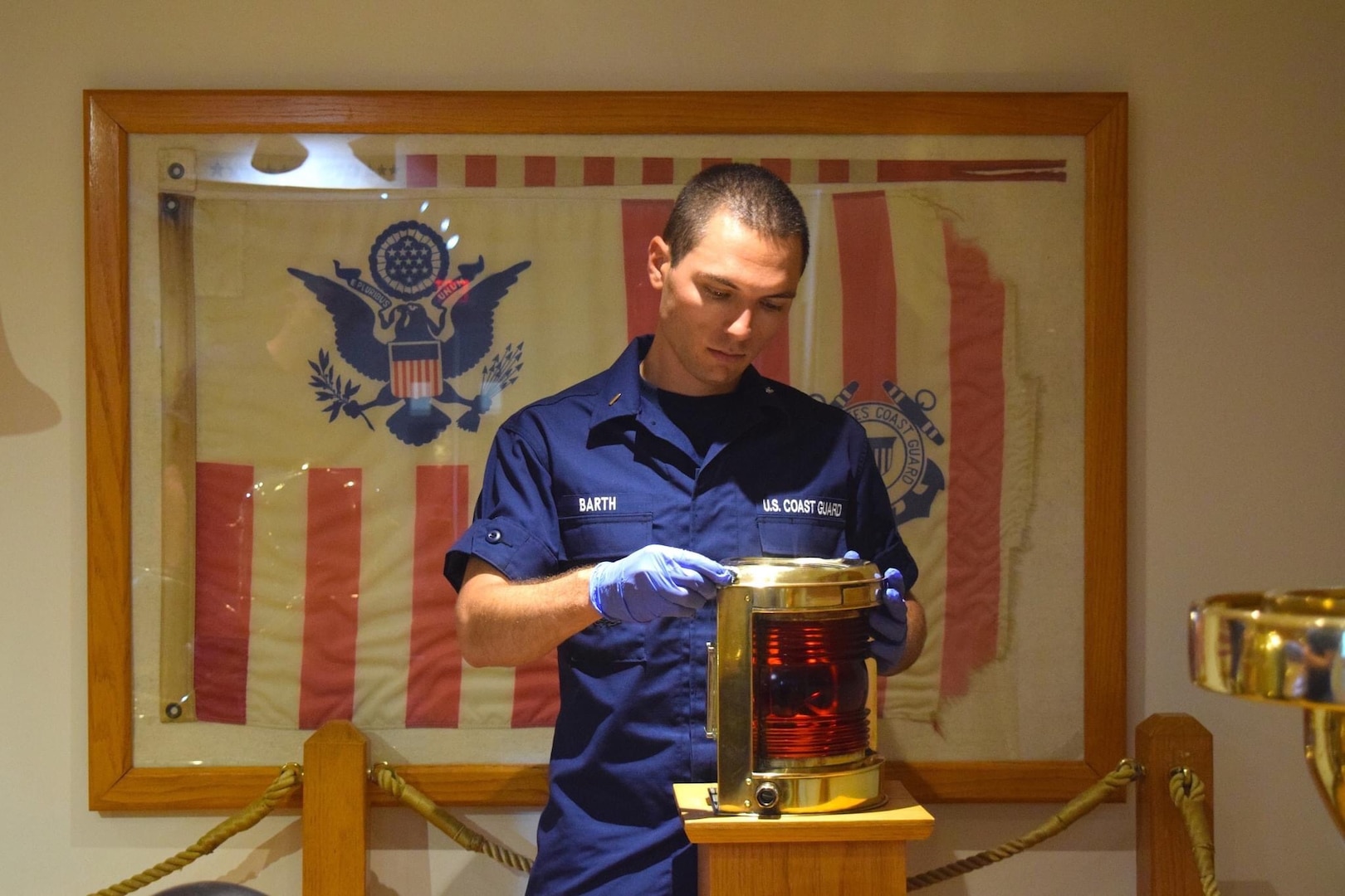 Ensign Michael Barth shines brass on the Coast Guard Cutter Cuyahoga Memorial while serving as an officer candidate in June 2022. The Cuyahoga was an officer candidate training vessel that sunk after a collision in which 11 officer candidates were lost. (Coast Guard Photo, Leadership Development Center)