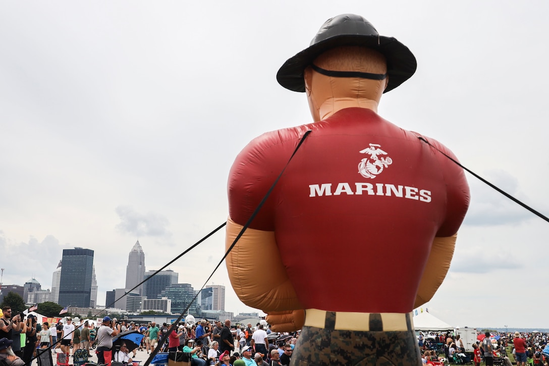 An inflatable drill instructor is held high for an enhanced area canvassing event, at the Cleveland Air Show, in Cleveland, September 2, 2022. The event provided an opportunity for recruiters to engage with the local community and to invite civilians to participate in a pull-up challenge to earn Marine Corps prizes. (U.S. Marine Corps photo by Sgt. Nello Miele)