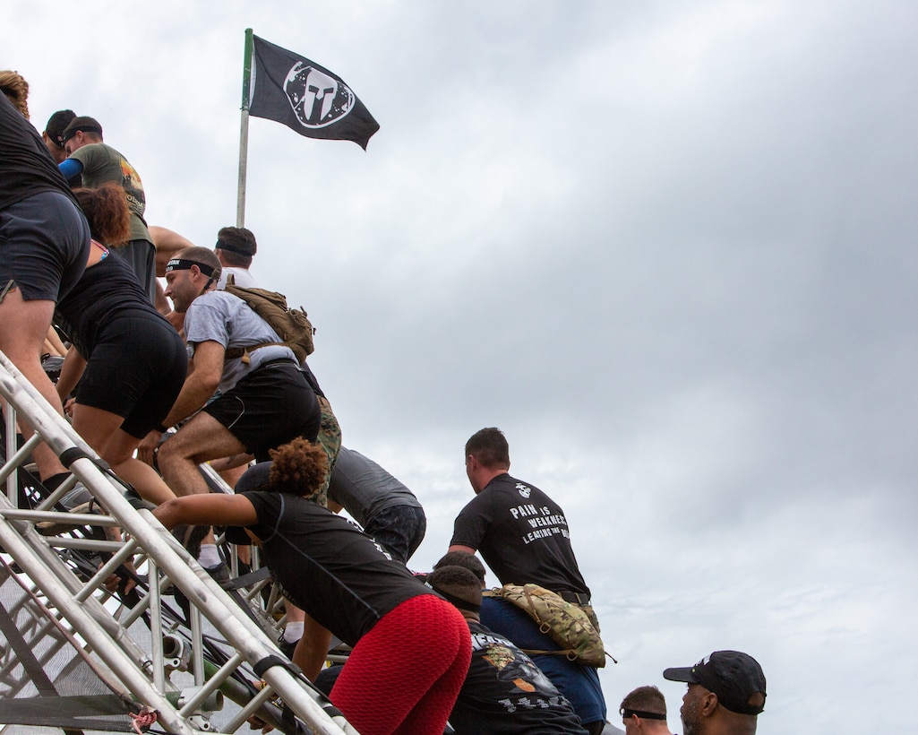 U.S. Marines and "Spartans" climb an obstacle during the Nashville Spartan Event Weekend in Lebanon, Tennessee, Oct. 16, 2022.  The Marine Corps partnered with the Spartan Races in order to engage with the athletic community and support recruiting efforts.  (U.S. Marine Corps photo by Cpl. Bernadette Pacheco)