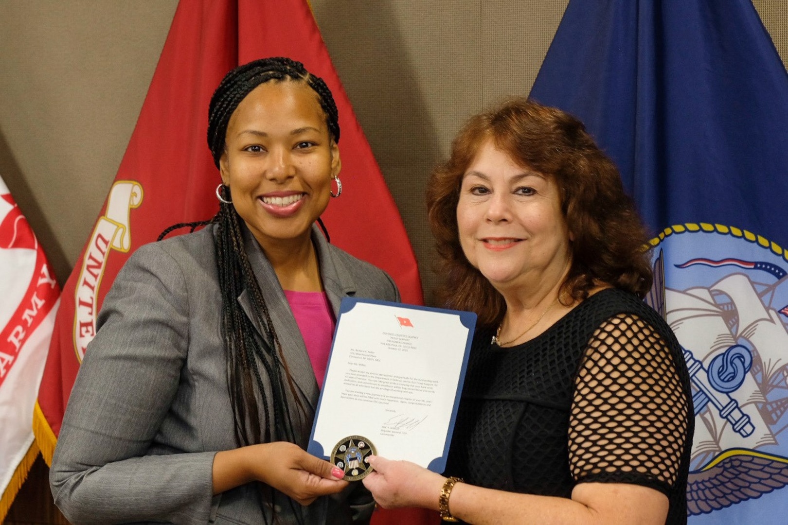 DLA Troop Support Deputy Commander Kishayra Lambert presents a certificate of retirement to Barbara Miller, Logistics Specialist with the Subsistence supply chain, during a ceremony held Oct 24, in Philadelphia. Miller retired from the DLA Troop Support after 41 years of service.
