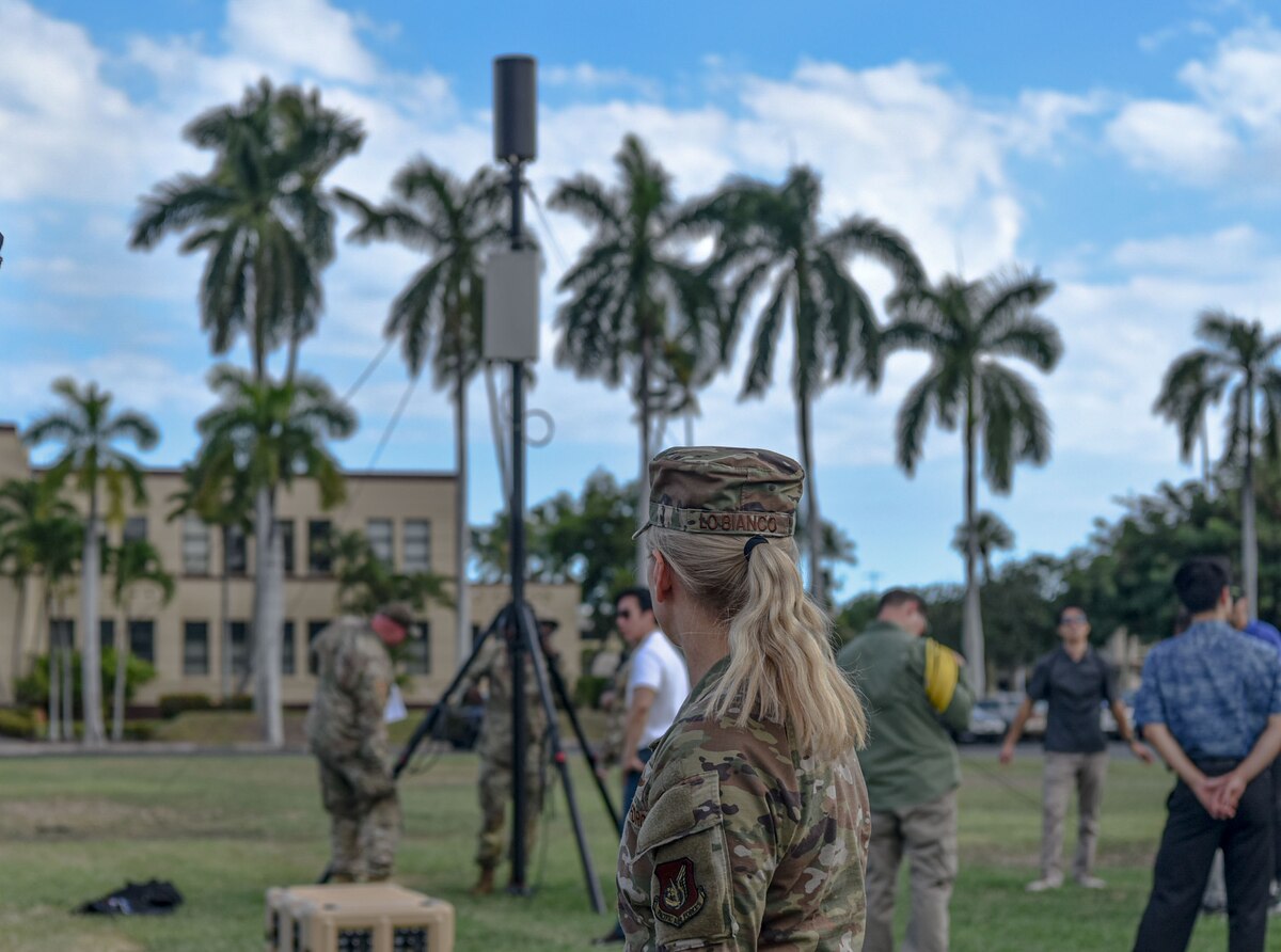 Col. Michele Lo Bianco, 15th Wing commander watches Airmen from the 15th Aircraft Maintenance Squadron and civilian partners from the Office of the Undersecretary of Defense for Research and Engineering demonstrate the portable operations network integrator at Joint Base Pearl Harbor-Hickam, Hawaii, Oct. 18, 2022. The PONi system can enhance military operations within an austere environment while reducing the footprint of a traditional forward-operating military unit. (U.S. Air Force photo by Tech. Sgt. Anthony Nelson Jr.)