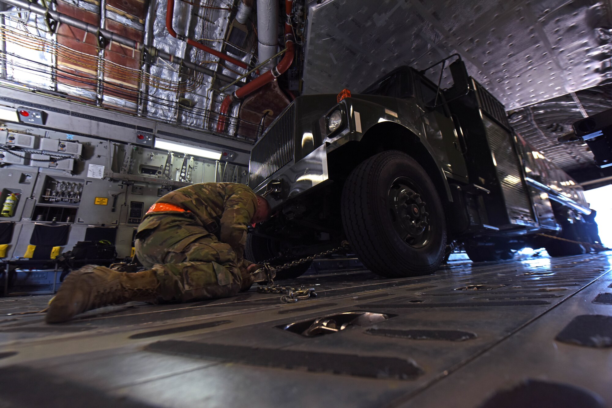 U.S. Air Force Staff Sgt. Kenneth Mullins, aerial porter with the 62d Aerial Port Squadron, secures a fuel truck in the cargo area of a C-17 Globemaster III aircraft during Exercise Rainier War 22B at Pocatello Regional Airport, Idaho, Oct. 18, 2022. Airmen from multiple Team McChord units came together to form the 7th Expeditionary Airlift Squadron during Rainier War 22B; which is a full-scale readiness exercise simulating a deployment in support of U.S. Indo-Pacific areas of responsibility. (U.S. Air Force photo by Staff Sgt. Zoe Thacker)
