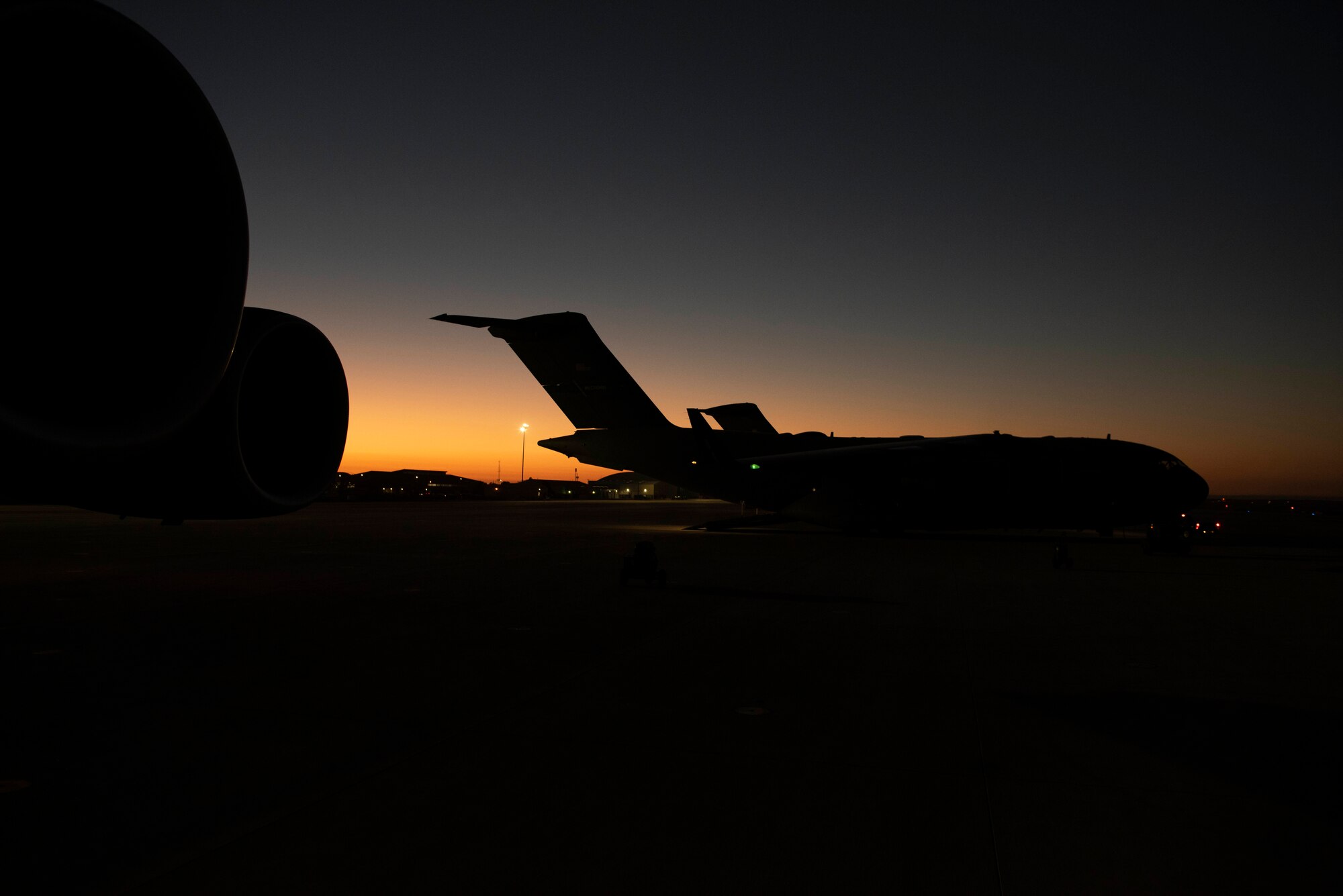 The sun rises above a 62d Airlift Wing C-17 Globemaster III aircraft on the flightline at Mountain Home Air Force Base, Idaho, Oct. 18, 2022. Alongside airlift operations, Team McChord also conducted cargo and personnel processing, chemical, biological, radiological and nuclear, and force protection scenarios, communication and connectivity degradation incidents and crisis scenarios during Exercise Rainier War 22B, from Oct. 6-22. (U.S. Air Force photo by Staff Sgt. Zoe Thacker)