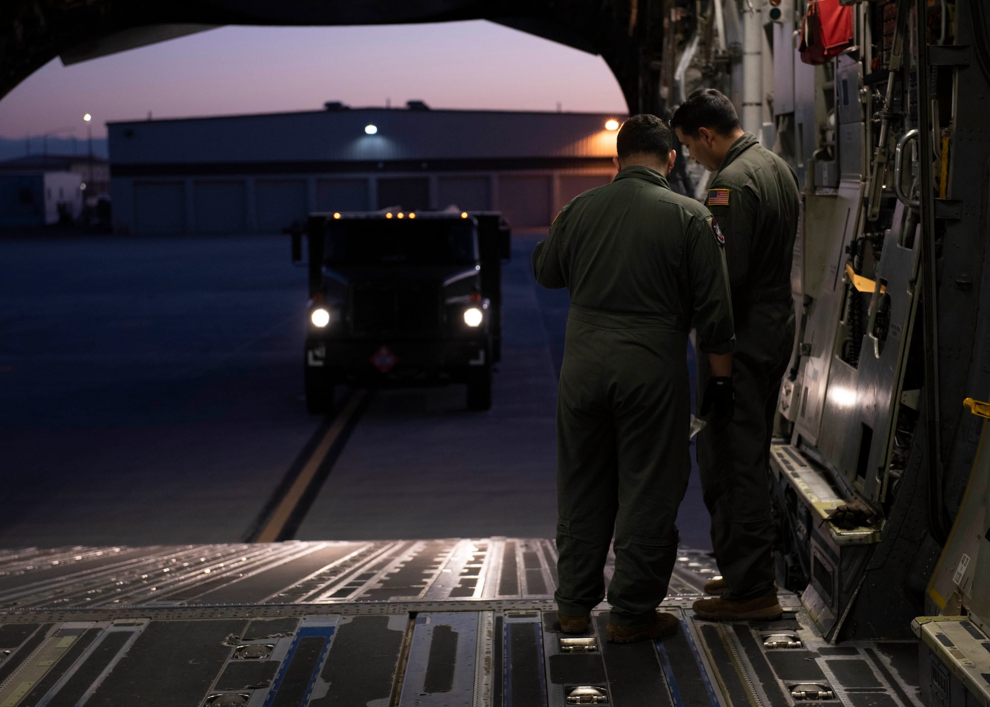 U.S. Air Force Staff Sgt. Michale Herrera, left, and Staff Sgt. Alonso Carrillo, both loadmasters with the 4th Airlift Squadron, prepare to load a fuel truck onto a C-17 Globemaster aircraft during Exercise Rainier War 22B at Mountain Home Air Force Base, Idaho, Oct. 18, 2022. Exercise Rainier War is the 62d Airlift Wing’s most expansive exercise, where they deploy as the lead wing and provide command and control and airlift capabilities like airdrop and airland. (U.S. Air Force photo by Staff Sgt. Zoe Thacker)