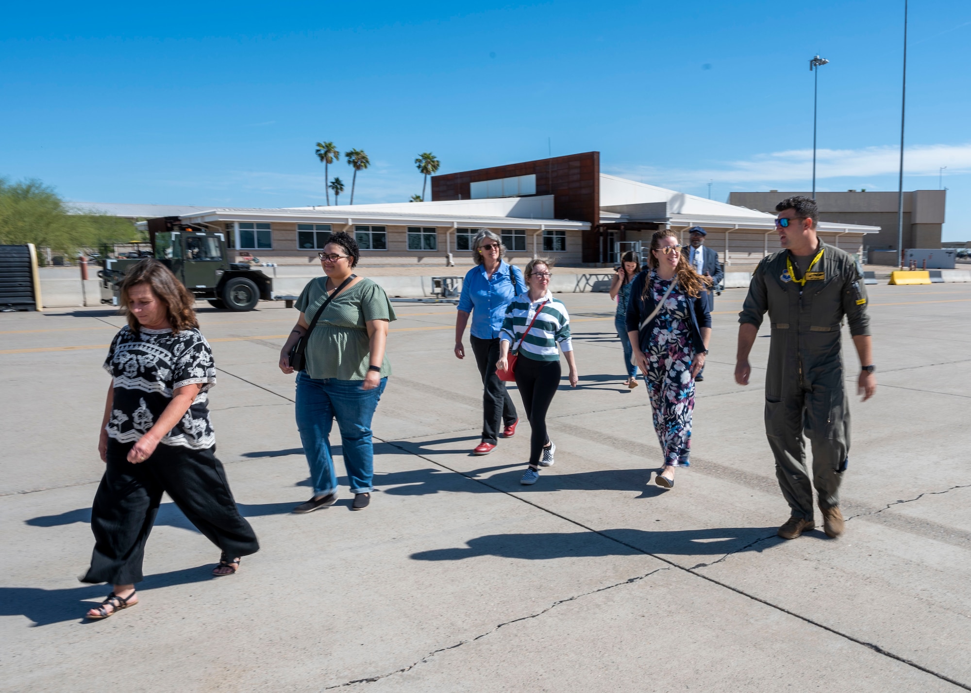 U.S. Air Force Major Brian Higgins, 61st Fighter Squadron instructor pilot (right), leads participants of the Heart Link Spouse Orientation onto the flightline Oct. 19, 2022, at Luke Air Force Base, Arizona.