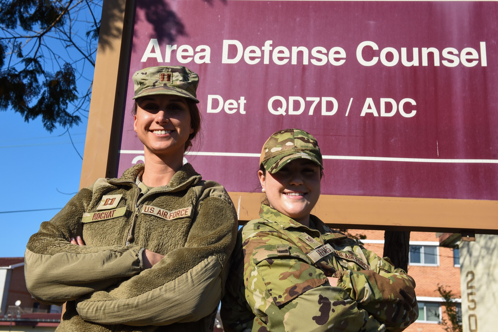 U.S. Air Force Capt. Kate Rochat, Air Force Legal Operations Agency Area Defense Council (left) and Staff Sgt. Reilly Hermes, AFLOA Defense Paralegal, pose in front of the sign outside of their office at Kunsan Air Base, Republic of Korea, Oct. 25, 2022. Area Defense Councils function entirely outside of a wing’s chain of command and provides members who are suspected of an office or face potential adverse actions with legal representation. (U.S. Air Force photo by Tech. Sgt. Timothy Dischinat)