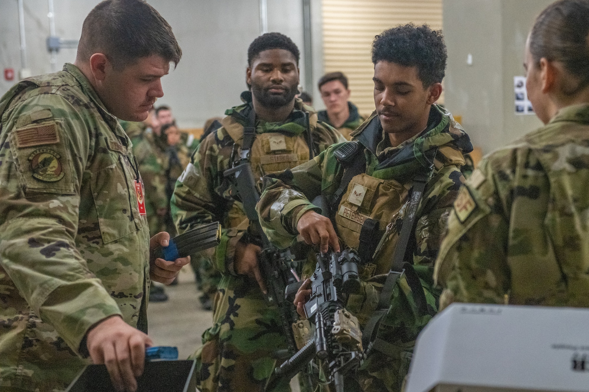 Security airmen in protective gear line up to check their rifles