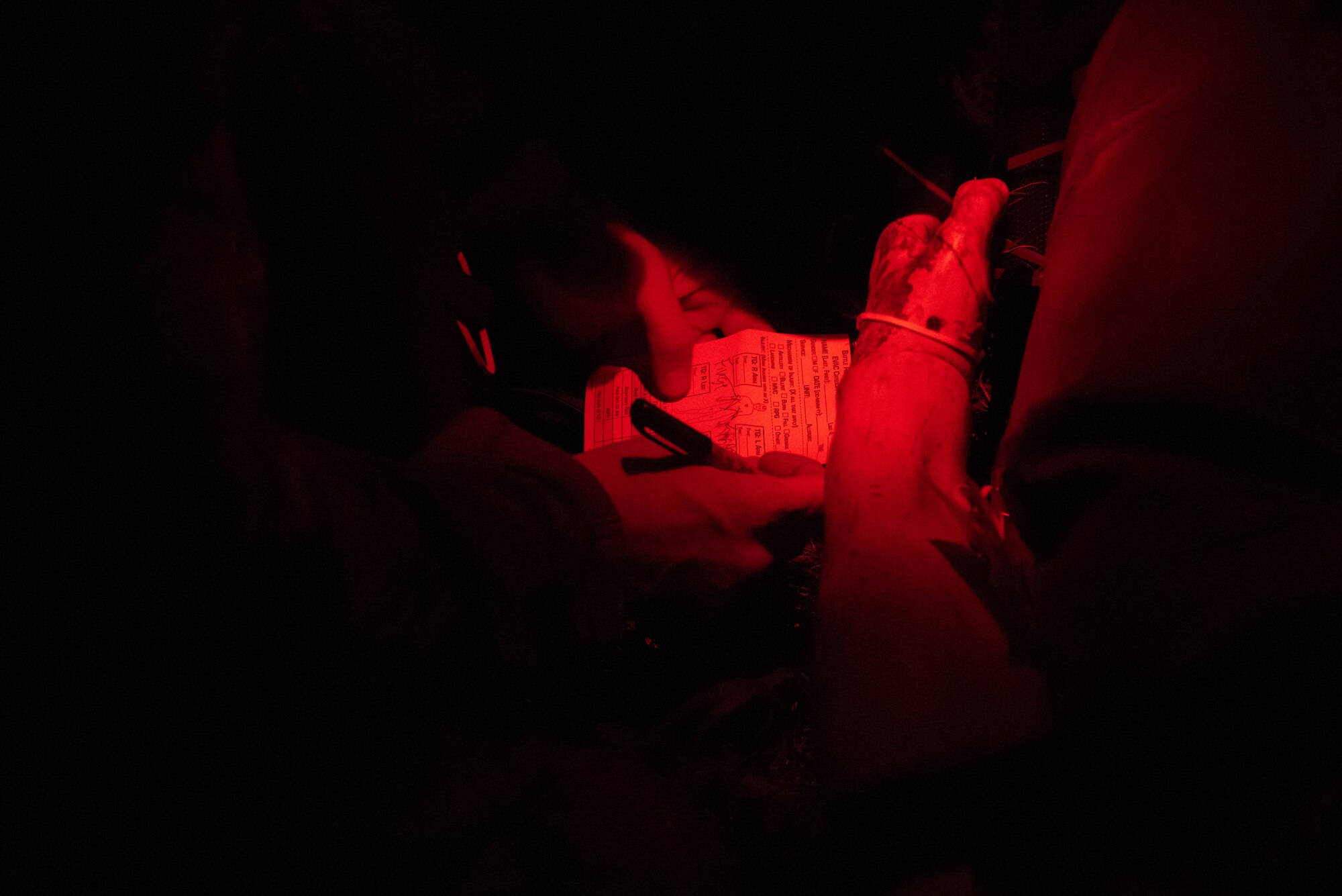 An Airman writes on a patient tag.