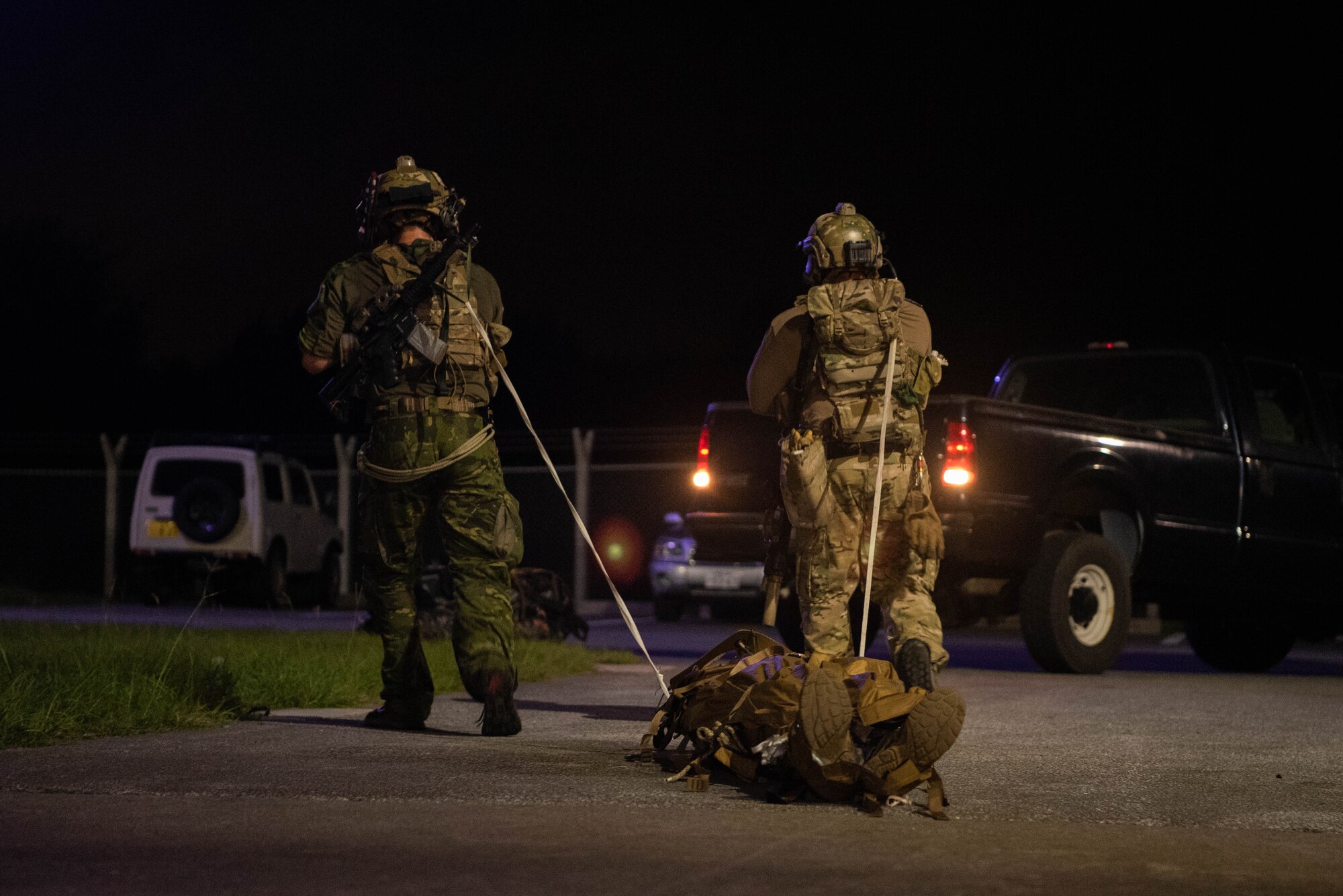 Airmen drag a litter holding a patient.