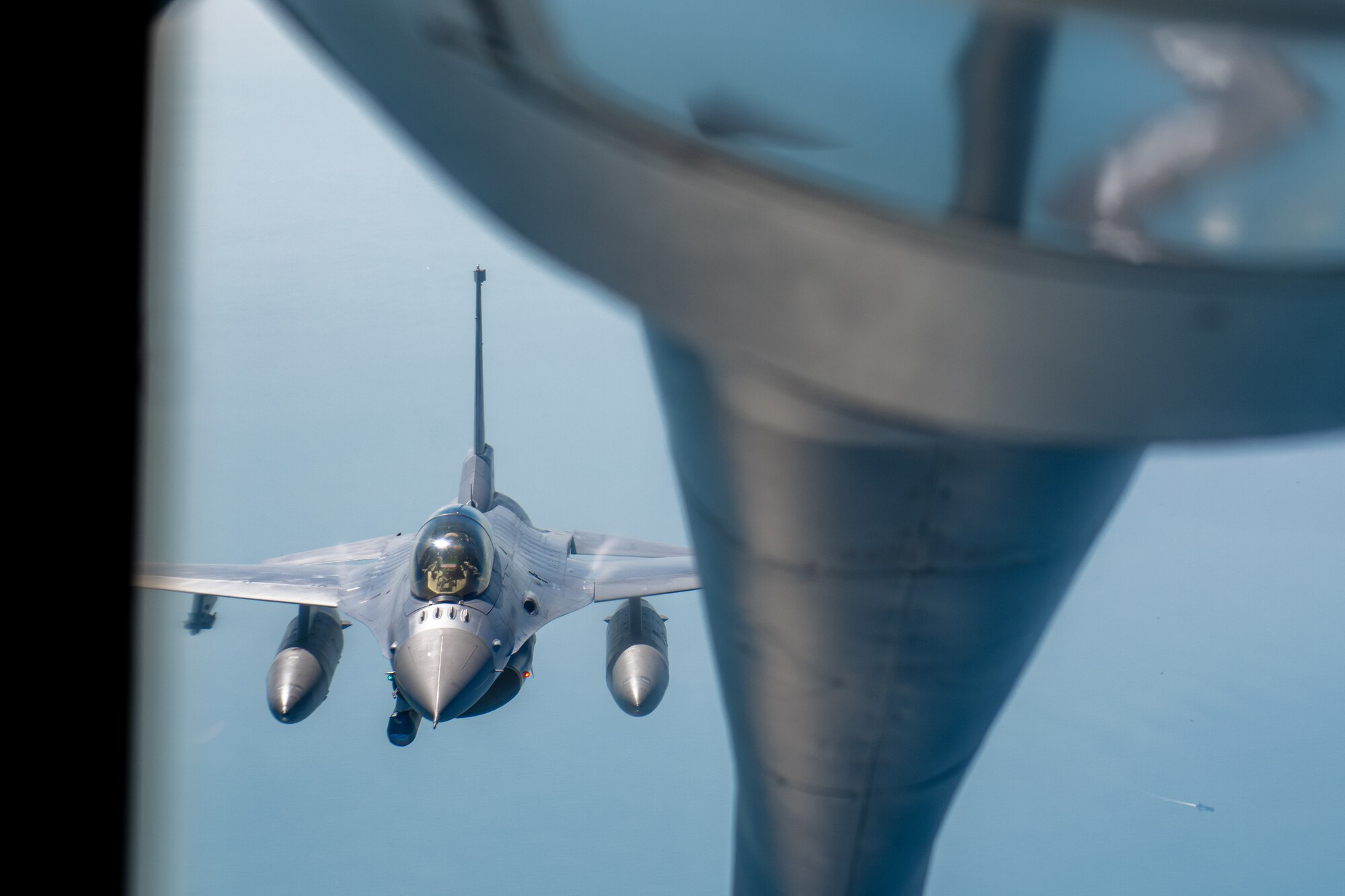 A F-16 peeks in at the boom operator of a KC-135 Stratotanker
