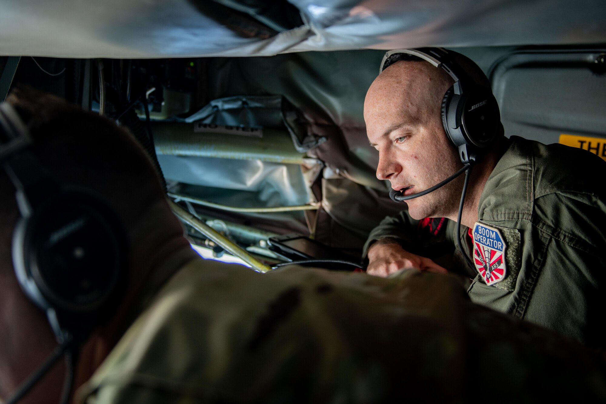 A boom operator gives instructions to a newer boom operator