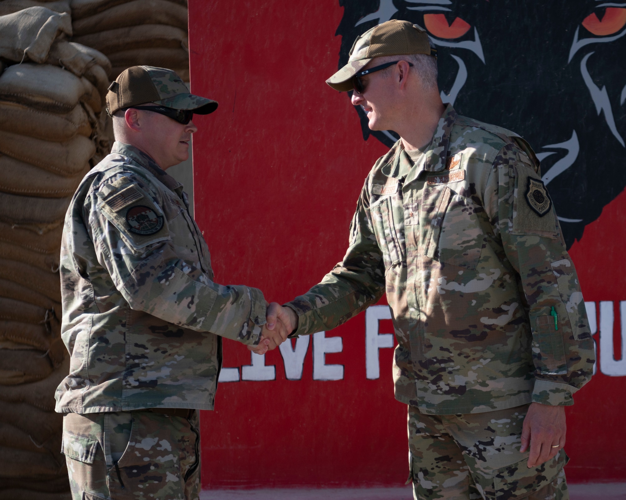 U.S. Air Force Tech. Sgt. Cory Williams, 332d Expeditionary Contracting Squadron, Commodity Flight Chief, receives a commander’s coin from Brigadier General Ryan R. Messer, 332d Air Expeditionary Wing Commander, at an undisclosed location, Southwest Asia, Oct. 11, 2022. Tech. Sgt. Williams was recognized as a superior performer for his end-of-year fiscal contributions to the 332d AEW. (U.S. Air Force photo by Tech. Sgt. Jeffery Foster)