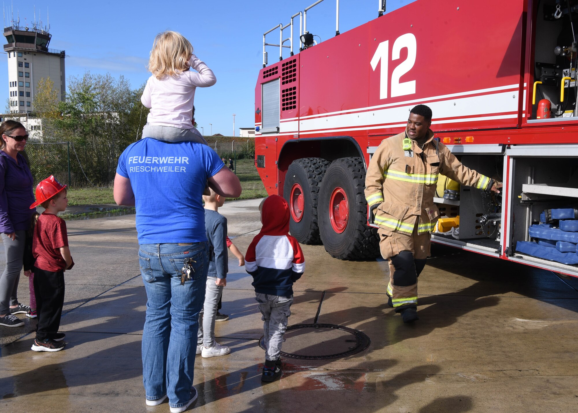 U.S. Air Force Staff Sgt. Austin James, 86th Civil Engineer Squadron fire department lead fire fighter, points out gear on a fire truck during a Fire Prevention Week open house at Ramstein Air Base