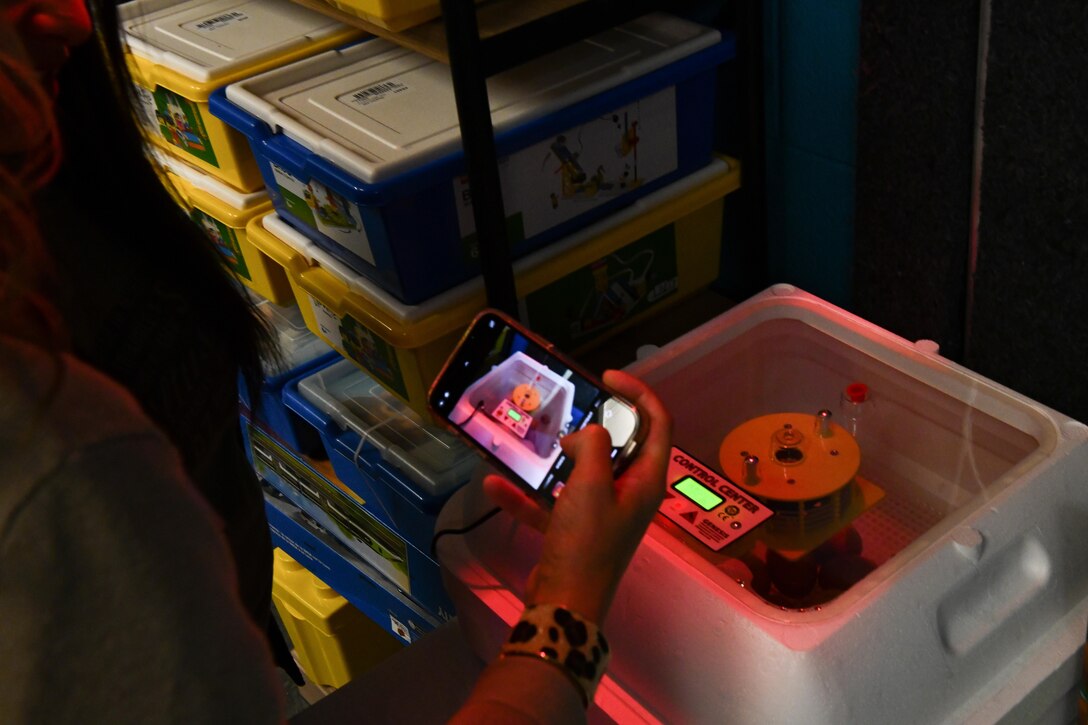 Tara Stewart, spouse of U.S. Air Force Lt. Col. Andy Stewart, 97th Mission Support Group deputy commander, takes a photo of chicken eggs in an incubator at the Youth Center during a leadership spouse tour at Altus Air Force Base, Oklahoma, Oct. 19, 2022. The school-age program at the Youth Center provides immersive activities including arts and crafts, fitness activities, a computer lab, library and more. (U. S. Air Force photo by Airman 1st Class Miyah Gray)