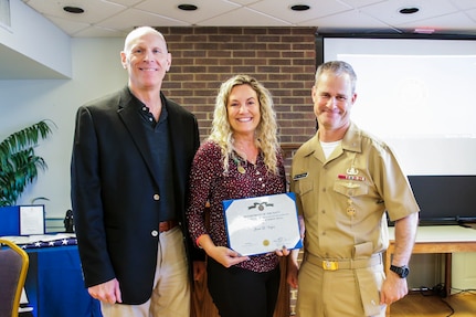 NSWC IHD Protocol Officer Janet Virgin poses with the Civilian Service Achievement Medal alongside NSWC IHD Technical Director Ashley Johnson and Commanding Officer Capt. Eric Correll, Sept. 29.