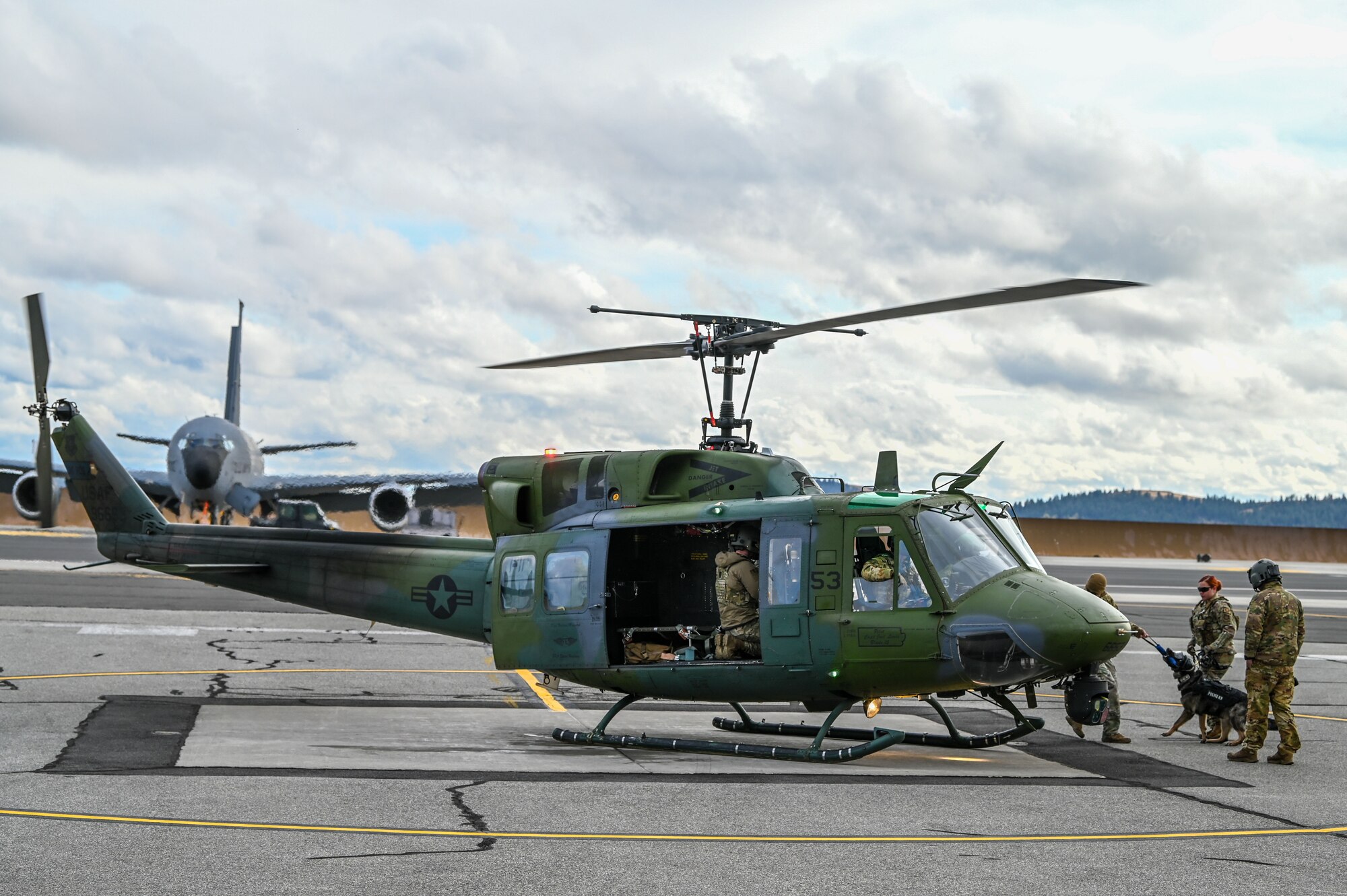 U.S. Air Force Military Working Dog handlers from the 92nd Security Forces Squadron and MWD Leo board a UH-1N Huey for familiarization training at Fairchild Air Force Base, Washington, Oct. 25, 2022. Military Working Dogs were trained how to properly board and ride in a helicopter to ensure safety on future missions. (U.S. Air Force photo by Airman 1st Class Stassney Davis)