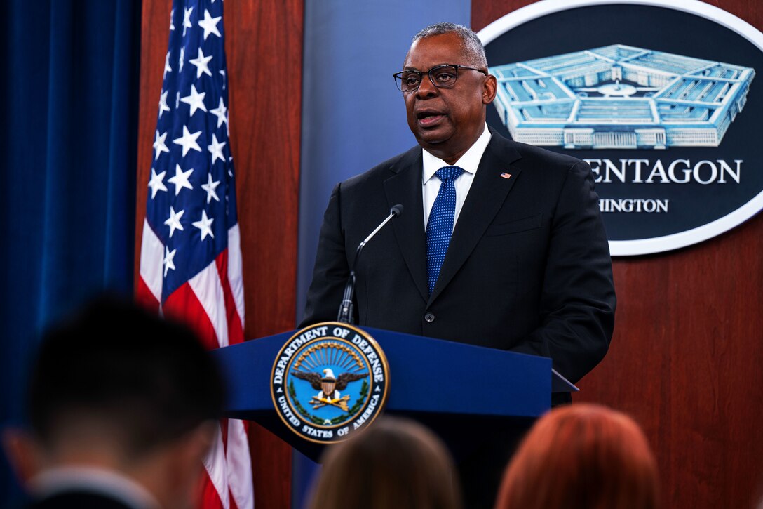 A man speaks from a podium to an audience.