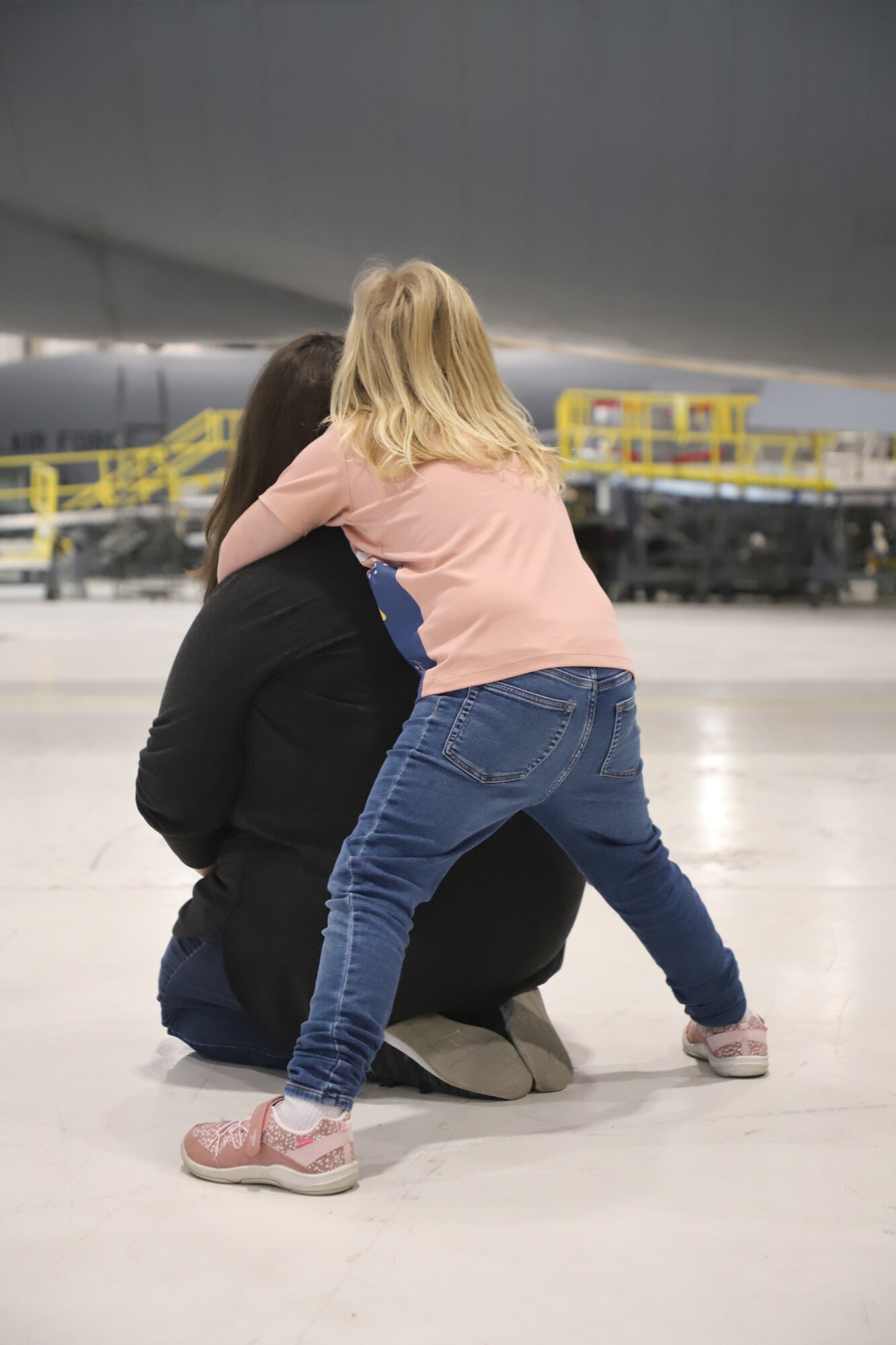 Tinley Benyshek, Pilot for the Day, hugs her mother, Tia Benyshek, at the 190th Air Refueling Wing in Topeka, KS, October 24, 2022. Tinley is the first Pilot for a Day participant at the 190th ARW.