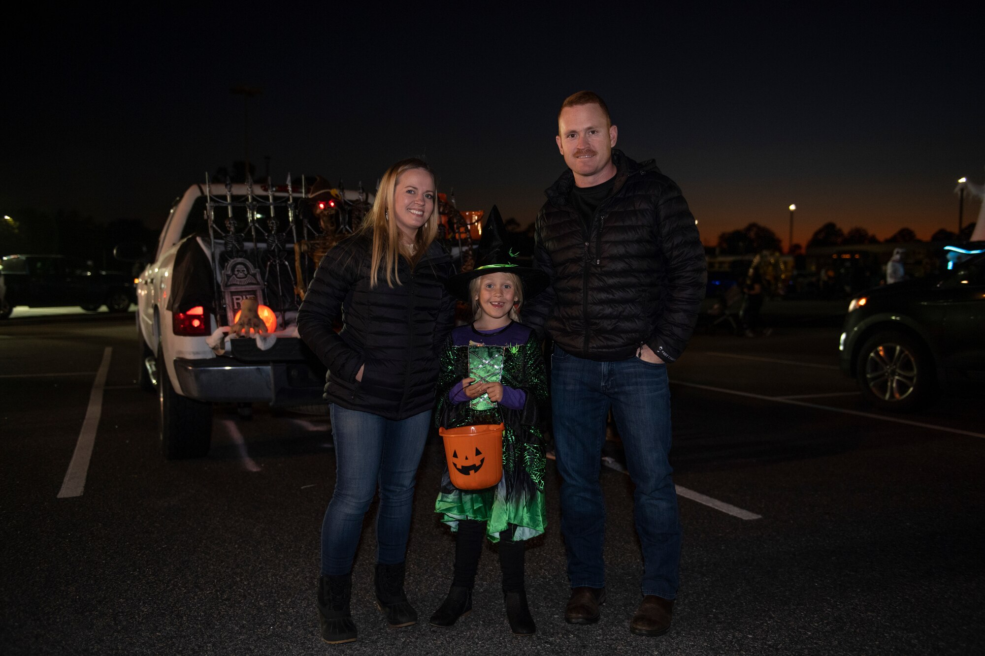 A photo of a family of three posing for a photo.