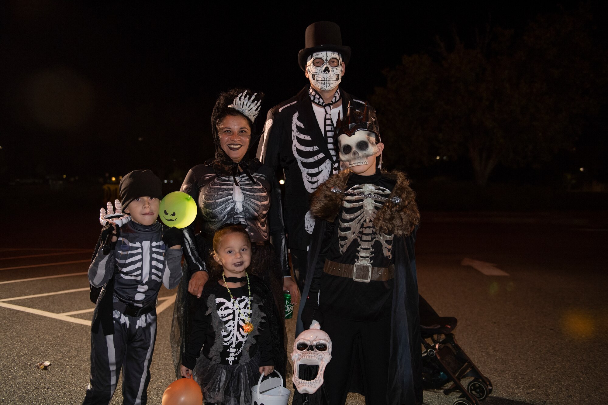 A photo of a family of five posing for a photo wearing skeleton costumes.