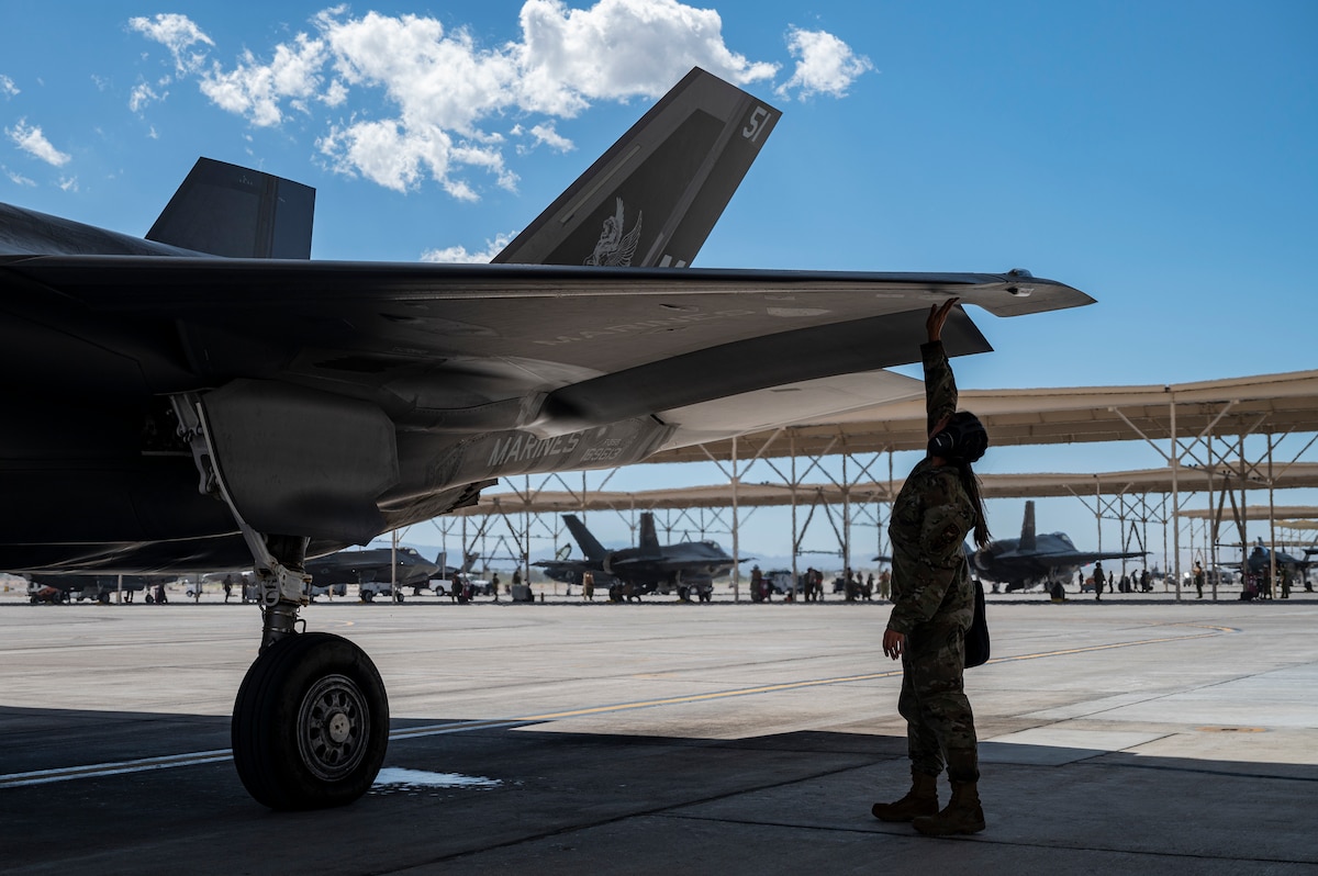 Staff Sgt. Keyli Pillaro-Estrada, 57th Aircraft Maintenance Squadron crew chief, conducts pre-flight checks on a Marine Corps F-35B Lightning II prior to a flight during Black Flag 22-2, at Nellis Air Force Base, Nevada, Sept. 21, 2022. Pillaro-Estrada, normally an Air Force F-35A crew chief, tested interoperability with the Marine Corps version, the F-35B. (U.S. Air Force photo by William R. Lewis)