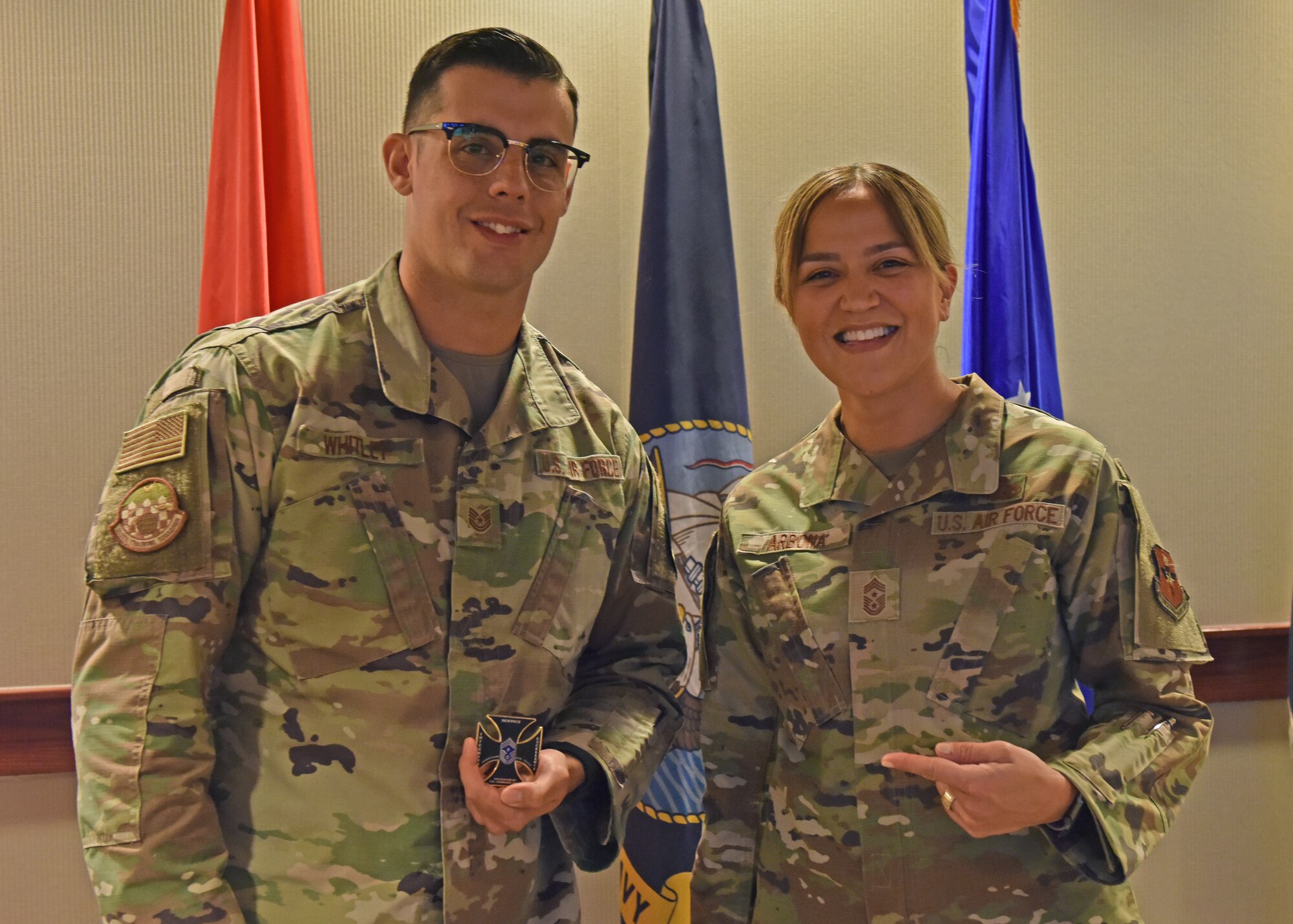 U.S. Air Force Tech. Sgt. Phillip Whitley, 315th Training Squadron geospatial-intelligence instructor, holds a coin presented by Chief Master Sgt. Rebecca Arbona, 17th Training Wing command chief, at Goodfellow Air Force Base, Texas, Oct. 18, 2022. Whitley was recognized as the October Member of the Month for his efforts as a member of the 17th Training Group. (U.S. Air Force photo by Airman 1st Class Zachary Heimbuch)