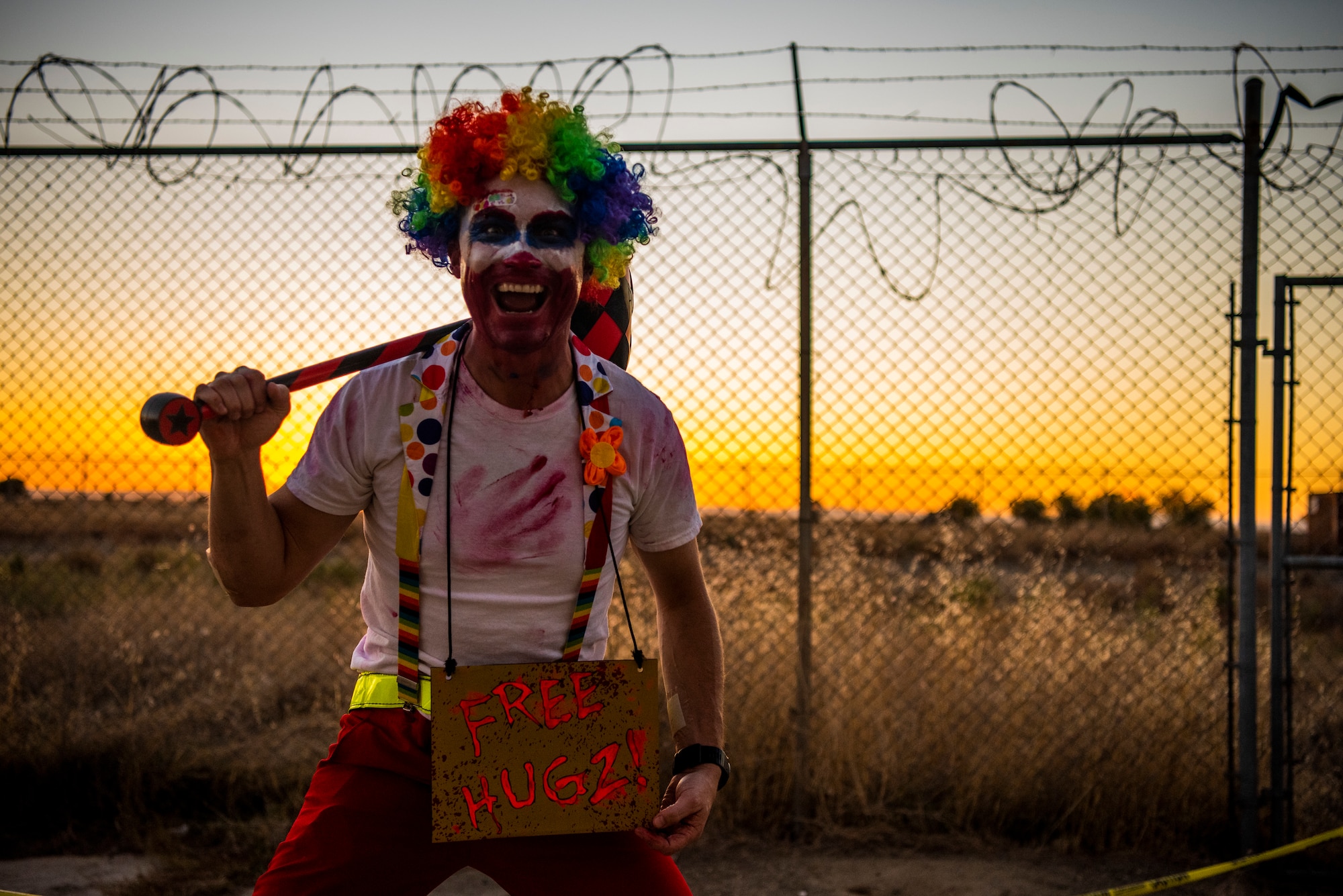 Beale volunteer Airman smiles while holding a sign at the haunted house
