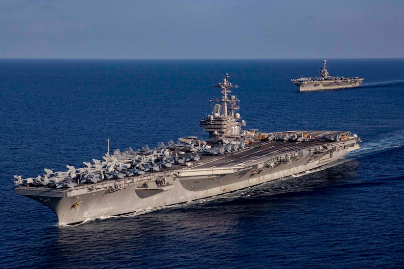 Two large ships traverse an ocean.