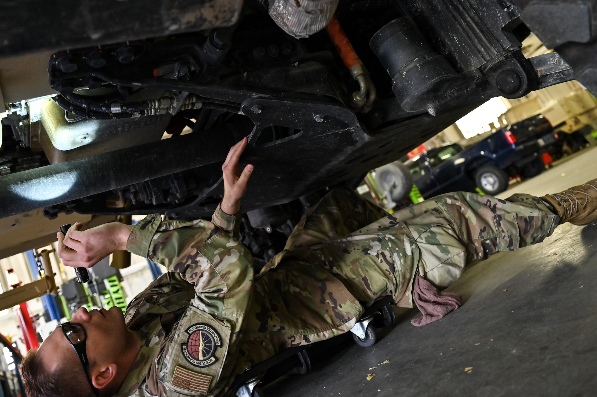 Senior Airman Korey Sarantopoulos, 90th Logistics Readiness Squadron vehicle maintenance journeyman, inspects the undercarriage to check the electrical, brake, fuel, cooling and other systems for serviceability as part of a Joint Light Tactical Vehicle limited technical inspection at F.E. Warren Air Force Base, Wyoming, Oct 25, 2022. The 90 LRS is tasked with preparing the next generation of security forces vehicles sent to protect the 90th Missile Wing's ICBM system as part of Air Force Global Strike Command’s priority to modernize. (U.S. Air Force photo by Joseph Coslett)