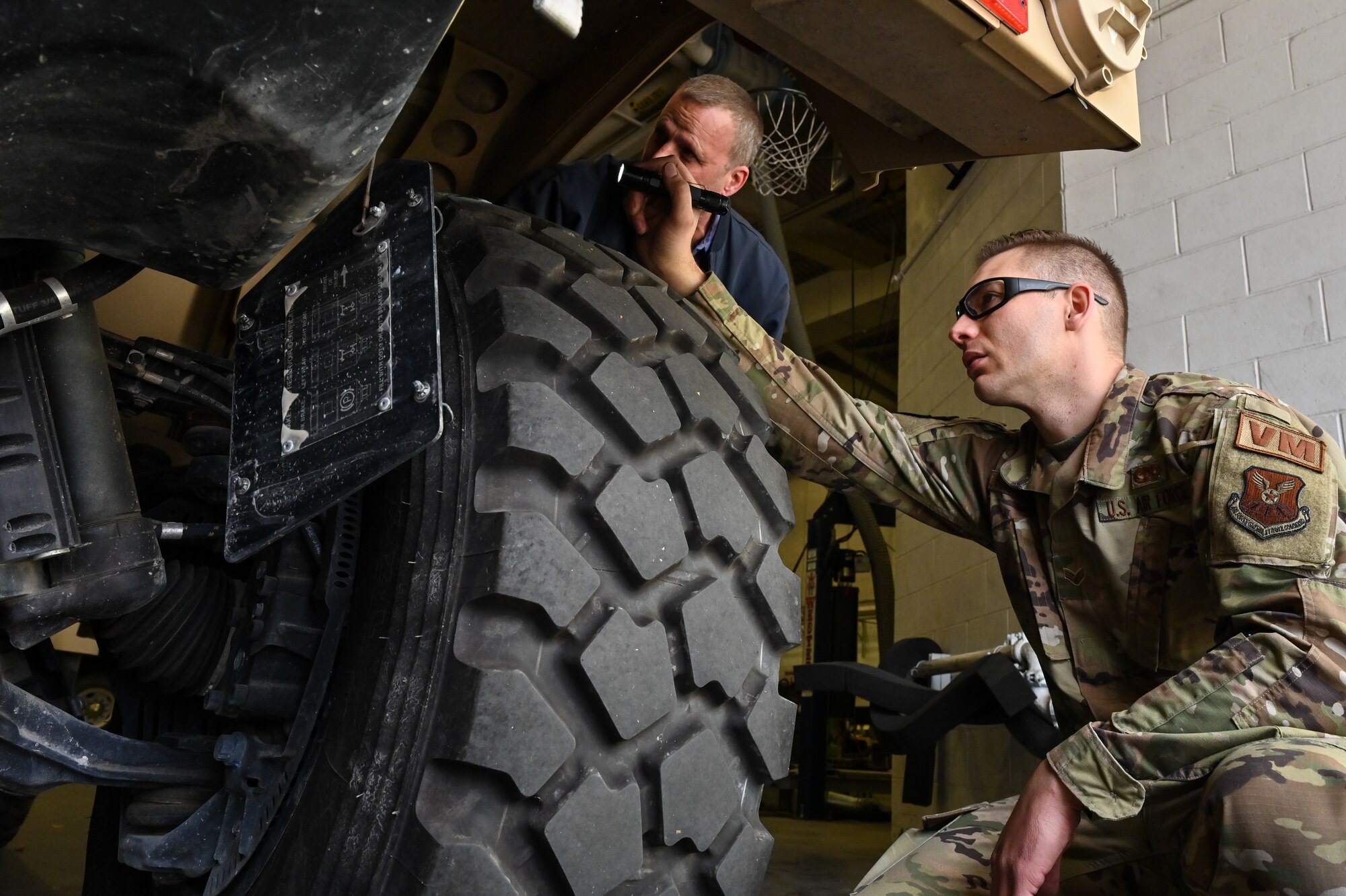 Mark Bramman, 90th Logistics Readiness Squadron vehicle maintenance craftsman, shows Senior Airman Korey Sarantopoulos, 90 LRS vehicle maintenance journeyman, the brake reservoir for the independent suspension as part of a Joint Light Tactical Vehicle limited technical inspection at F.E. Warren Air Force Base, Wyoming, Oct 25, 2022. The 90 LRS is tasked with preparing the next generation of security forces vehicles sent to protect the 90th Missile Wing's ICBM system as part of Air Force Global Strike Command’s priority to modernize. (U.S. Air Force photo by Joseph Coslett)