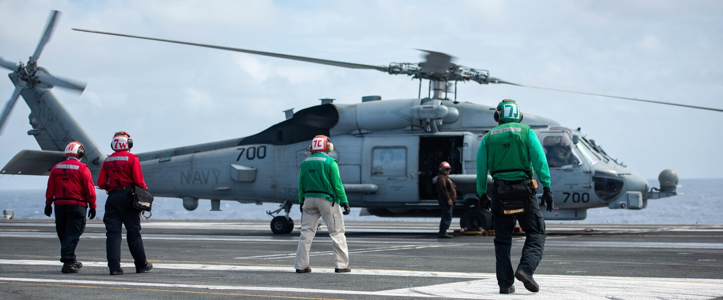 PHILIPPINE SEA (Oct. 27, 2022) Sailors prepare an MH-60R Sea Hawk, attached to the Saberhawks of Helicopter Maritime Strike Squadron (HSM) 77, for take-off on the flight deck of the U.S. Navy’s only forward-deployed aircraft carrier, USS Ronald Reagan (CVN 76), in the Philippine Sea, Oct. 27. HSM 77’s missions include surface warfare, anti-submarine warfare, and a variety of support roles for Ronald Reagan and Carrier Strike Group (CSG) 5. Ronald Reagan, the flagship of CSG 5, provides a combat-ready force that protects and defends the United States, and supports alliances, partnerships and collective maritime interests in the Indo-Pacific region. (U.S. Navy photo by Mass Communication Specialist 3rd Class Eric Stanton)