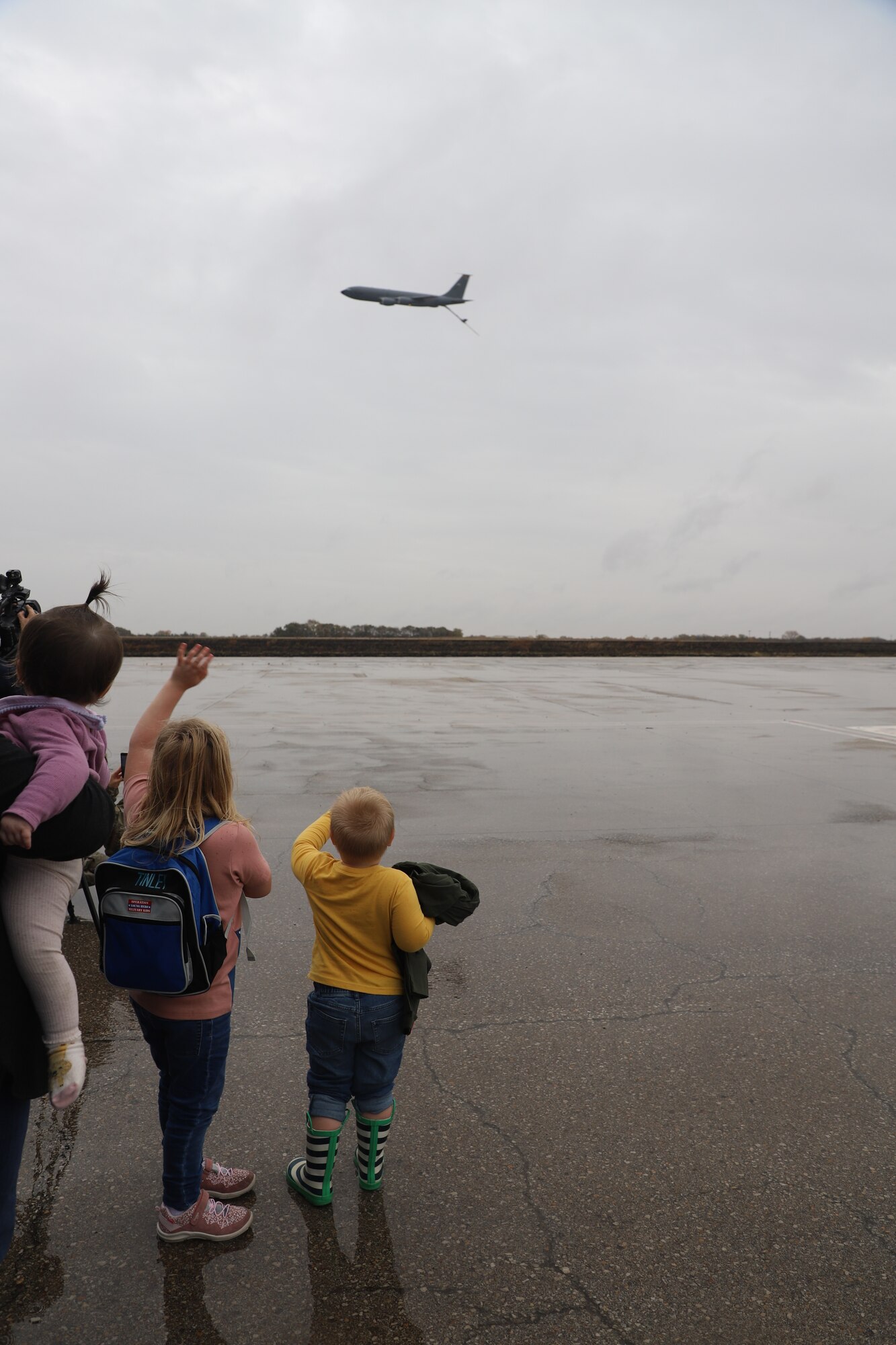Tinley Benyshek, Pilot for the Day, and her brother, Trip, wave at a KC-135 that is flying by with its boom stick down at the 190th Air Refueling Wing in Topeka, KS, October 24, 2022. Tinley is the first Pilot for a Day participant at the 190th ARW.