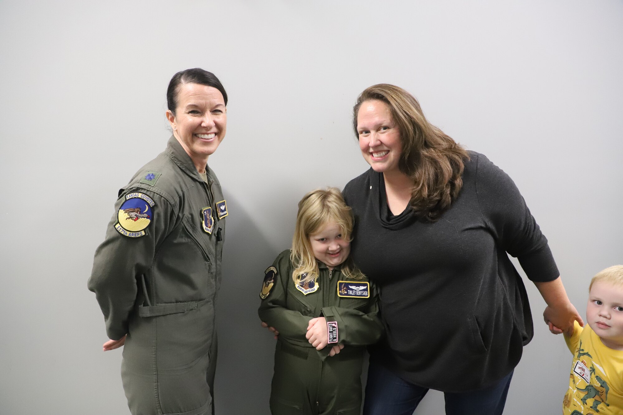 Tinley Benychek, Pilot for the Day, poses in her flight suit with Lt. Col. Marjorie Norton, 117th Air Refueling Squadron commander, and family at the 190th Air Refueling Wing in Topeka, KS, October 24, 2022. Tinley is the first Pilot for a Day participant at the 190th ARW.