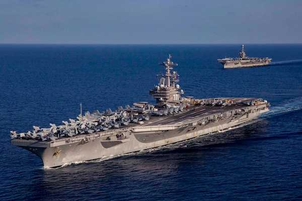 Two large ships traverse an ocean.