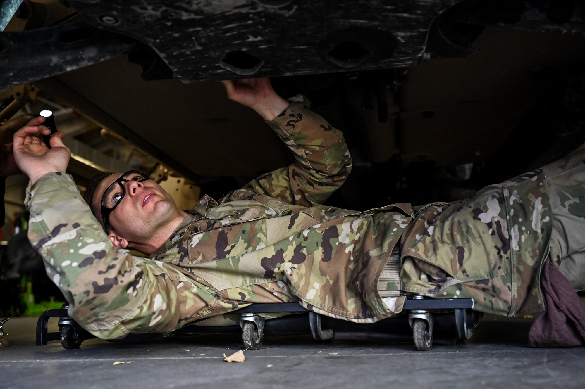 Senior Airman Korey Sarantopoulos, 90th Logistics Readiness Squadron vehicle maintenance journeyman, inspects the undercarriage to check the electrical, brake, fuel, cooling and other systems for serviceability as part of a Joint Light Tactical Vehicle limited technical inspection at F.E. Warren Air Force Base, Wyoming, Oct 25, 2022. The 90 LRS is tasked with preparing the next generation of security forces vehicles sent to protect the 90th Missile Wing's ICBM system as part of Air Force Global Strike Command’s priority to modernize. (U.S. Air Force photo by Joseph Coslett)