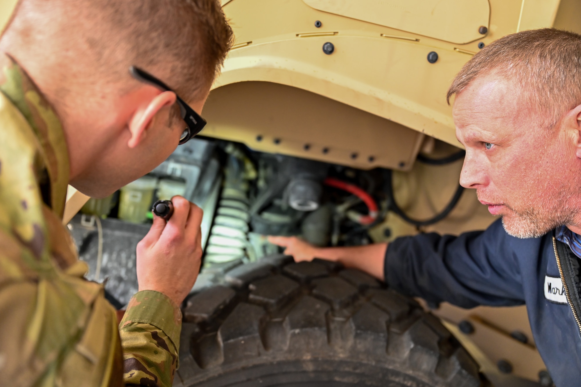 Mark Bramman, 90th Logistics Readiness Squadron vehicle maintenance craftsman, shows Senior Airman Korey Sarantopoulos, 90 LRS vehicle maintenance journeyman, the brake reservoir for the independent suspension as part of a Joint Light Tactical Vehicle limited technical inspection at F.E. Warren Air Force Base, Wyoming, Oct 25, 2022. The 90 LRS is tasked with preparing the next generation of security forces vehicles sent to protect the 90th Missile Wing's ICBM system as part of Air Force Global Strike Command’s priority to modernize. (U.S. Air Force photo by Joseph Coslett)