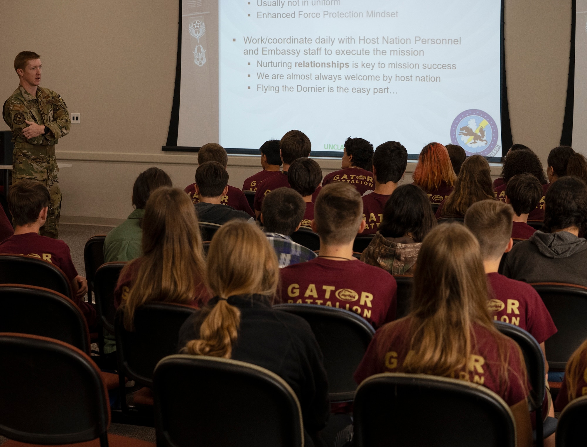 An Airman speaks to cadets sitting in an auditorium