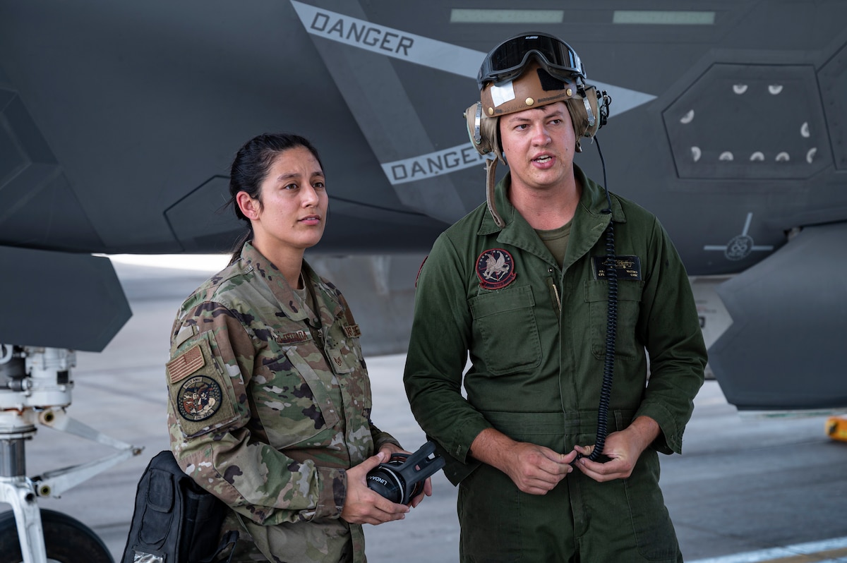 Staff Sgt. Keyli Pillaro-Estrada, 57 Aircraft Maintenance Squadron crew chief, talks with Marine Cpl. Jesse Mattics assigned to Marine Operational Test & Evaluation Squadron 1, Marine Corps Air Station Yuma, Arizona prior to a mission for Black Flag 22-2 at Nellis Air Force Base, Nevada, Sept 21. 2022.. Members of the Air Force, Navy and Marine Corps participated in consolidated F-35 Cross service maintenance and logistics training during Black Flag 22-2.  (U.S. Air Force photo by William R. Lewis)
