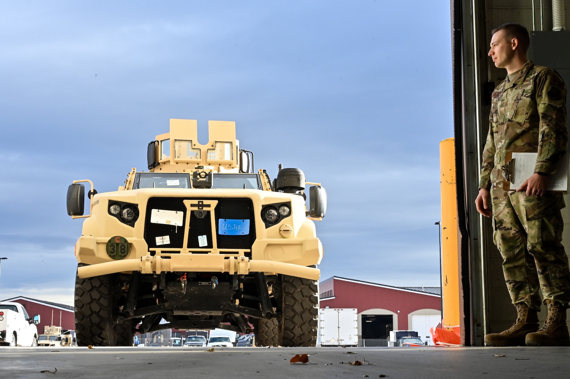 Senior Airman Korey Sarantopoulos, 90th Logistics Readiness Squadron vehicle maintenance journeyman, waits for Mark Bramman, 90 LRS vehicle maintenance craftsman, to drive a Joint Light Tactical Vehicle into the maintenance bay before performing a limited technical inspection on F.E. Warren Air Force Base, Wyoming, Oct 25, 2022. The 90 LRS is tasked with preparing the next generation of security forces vehicles sent to protect the 90th Missile Wing's ICBM missile system as part of Air Force Global Strike Command’s priority to modernize. (U.S. Air Force photo by Joseph Coslett)