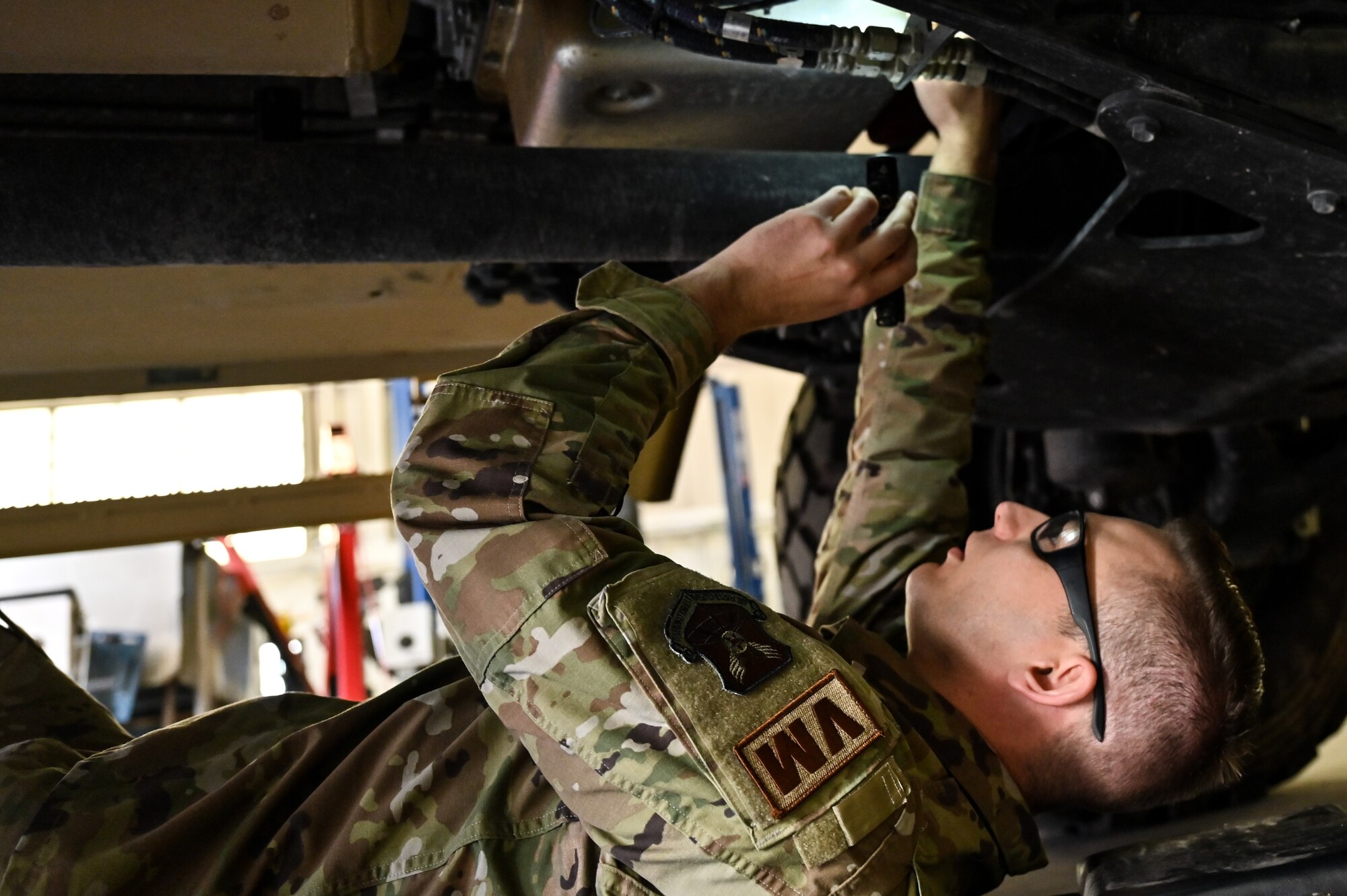 Senior Airman Korey Sarantopoulos, 90th Logistics Readiness Squadron vehicle maintenance journeyman, inspects the undercarriage to check the electrical, brake, fuel, cooling and other systems for serviceability as part of a Joint Light Tactical Vehicle limited technical inspection at F.E. Warren Air Force Base, Wyoming, Oct 25, 2022. The 90 LRS is tasked with preparing the next generation of security forces vehicles sent to protect the 90th Missile Wing's ICBM system as part of Air Force Global Strike Command’s priority to modernize. (U.S. Air Force photo by Joseph Coslett)